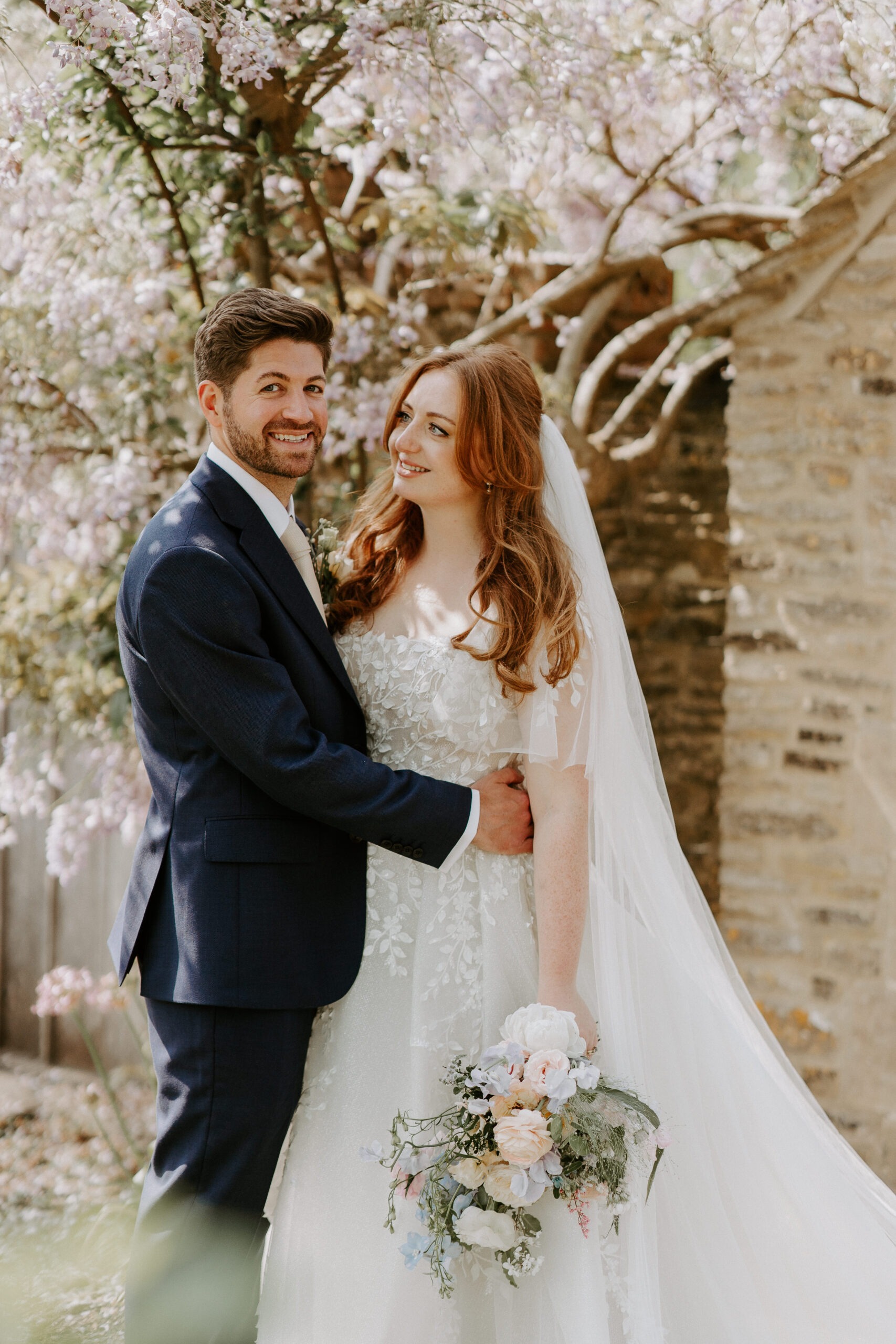 couple portraits at oxleaze barn under wysteria