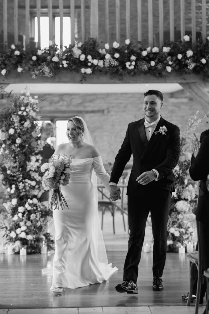Couple walking back down the aisle during their Kingscote Barn Wedding