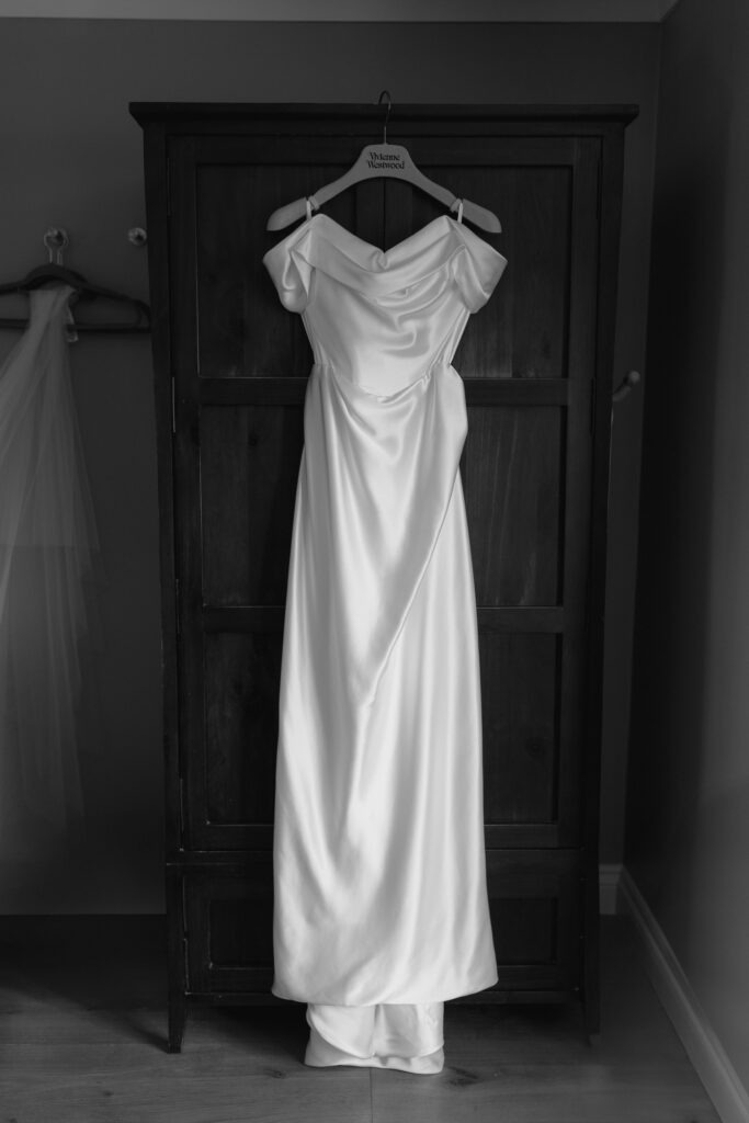 Katie in a Vivienne Westwood wedding dress standing in the garden at Cripps Barn, Cotswolds.