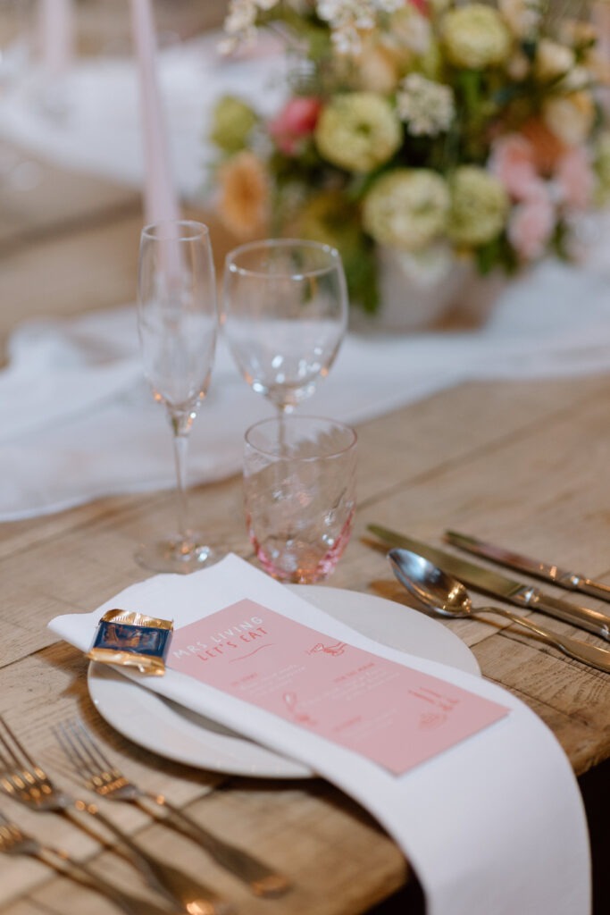 Cripps Barn’s ceremony space transformed for the wedding breakfast, with long tables and vibrant florals