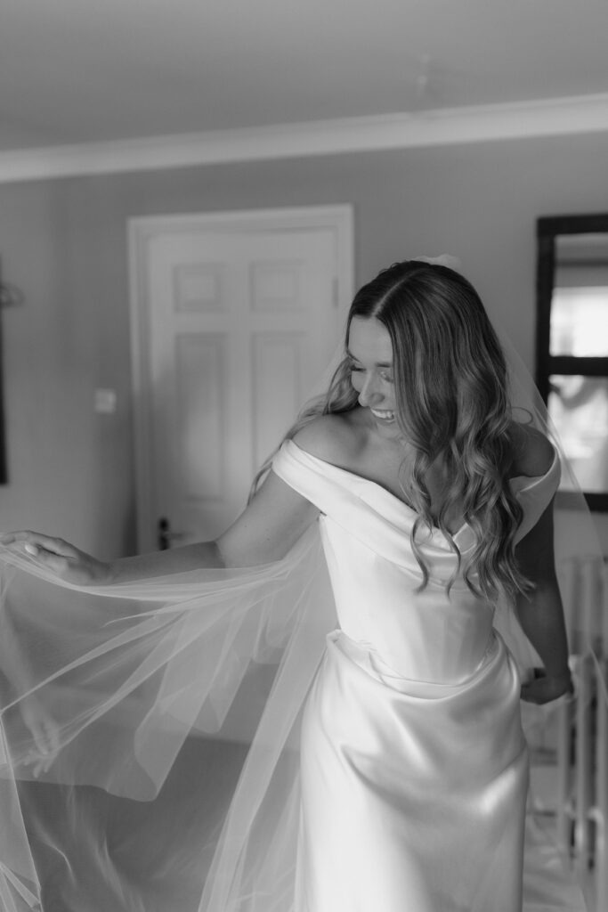 Katie in a Vivienne Westwood wedding dress standing in the garden at Cripps Barn, Cotswolds.