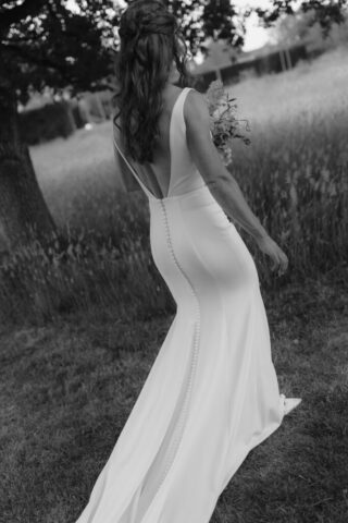 Bride holding bouquet, wandering the grounds of Kin House