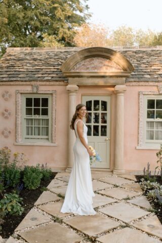 Bride holding bouquet, wandering the grounds of Kin House